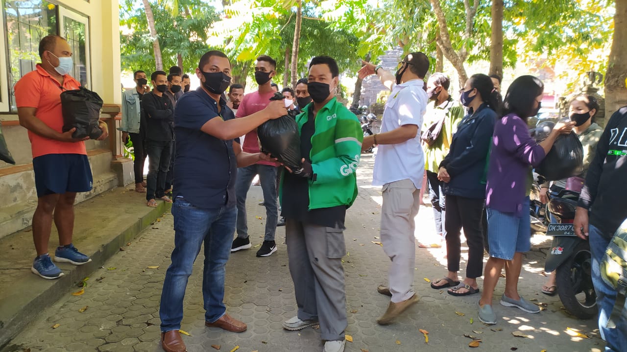 Direktur PT Indojet Sarana Aviasi, Stefanus Gandi menyerahkan bantuan sembako kepada salah satu warga Denpasar, disaksikan puluhan wartawan asal NTT di Bali, Sabtu (18/07/2020). Foto: Dok PENA NTT Bali